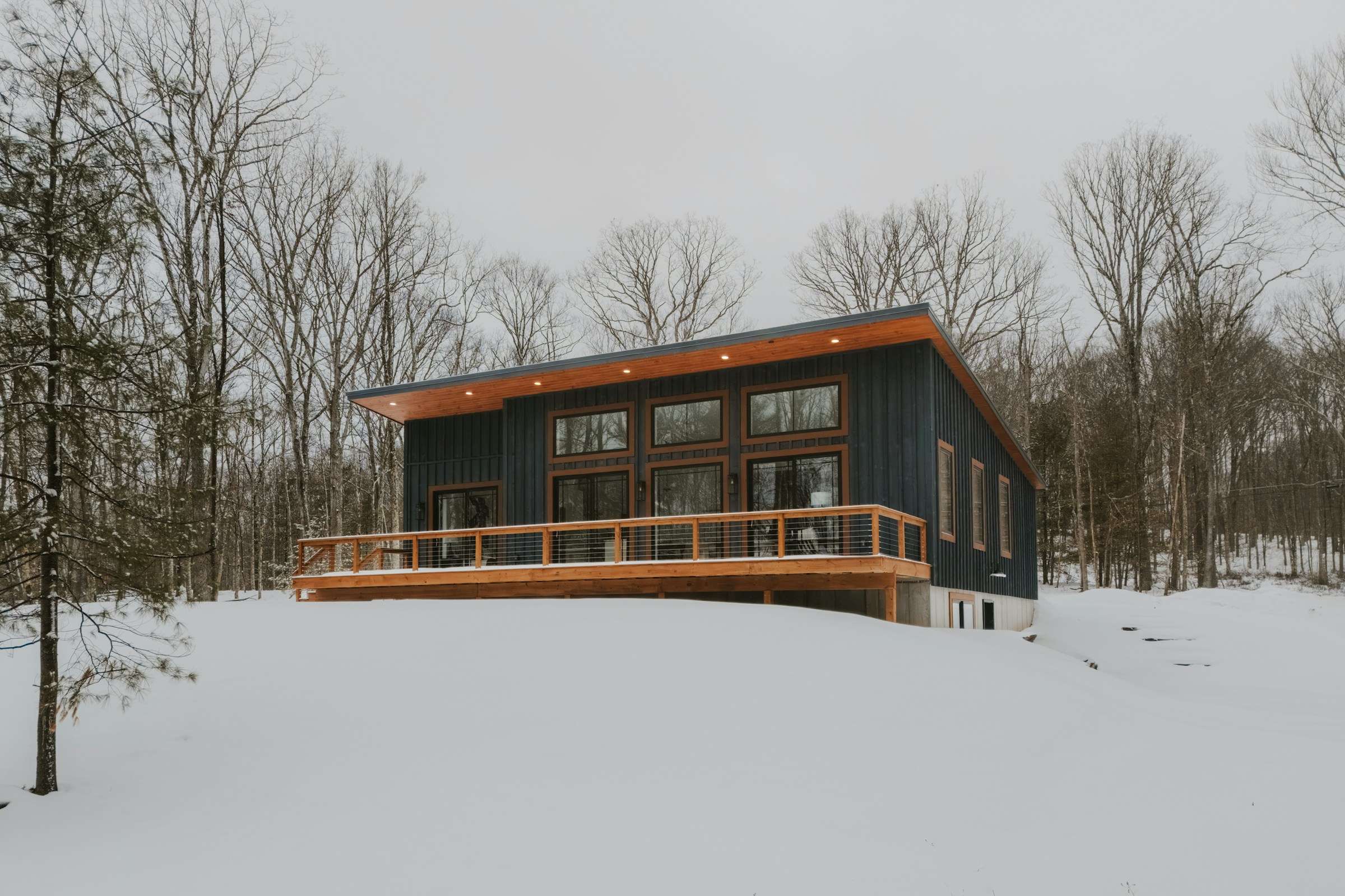 Custom home in winter with a cedar deck